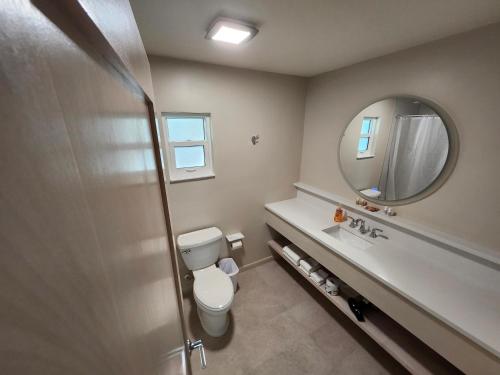 萨尼贝尔Sunshine Island Inn的一间带卫生间、水槽和镜子的浴室
