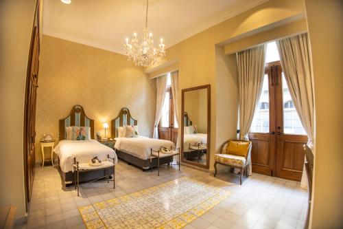 巴拿马城La Concordia - Boutique Hotel的一间卧室配有两张床和吊灯。