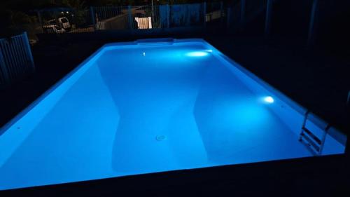 莱特鲁瓦西莱Beautiful Day Studio的深色客房内的游泳池,灯光蓝色