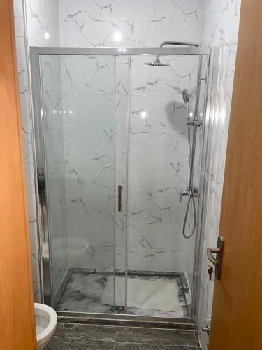 普拉亚madison place的浴室里设有玻璃门淋浴