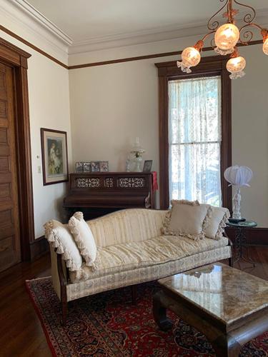昆西Historic Queen Anne Mansion的客厅配有沙发和桌子