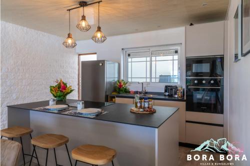 波拉波拉Matira Beach House的一间厨房,内设一个柜台和凳子