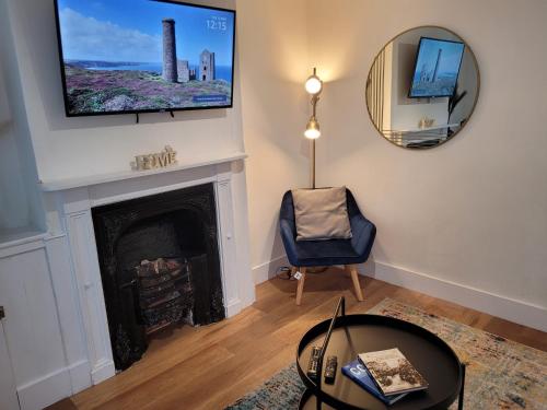 科尔切斯特Greenstead road - Cosy house in Town的客厅设有壁炉和墙上的电视