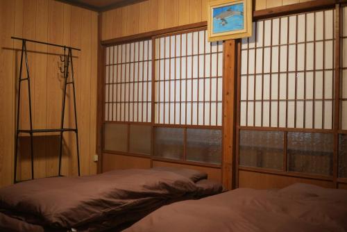 Mamiharaomusubi guest house (JAPANESE　STYLE）的一间卧室设有一张床、一个窗口和一张床