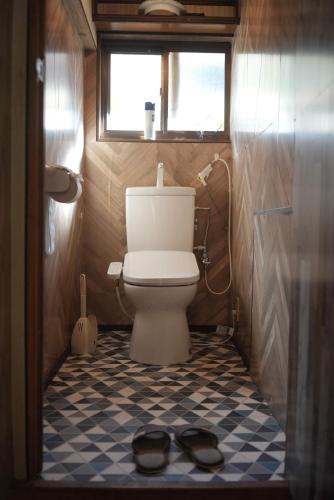 Mamiharaomusubi guest house (JAPANESE　STYLE）的浴室设有卫生间,地板上备有一双鞋。
