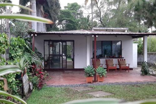 阿马蒂特兰Jardín Paraíso的白色的小房子,设有配有椅子的庭院