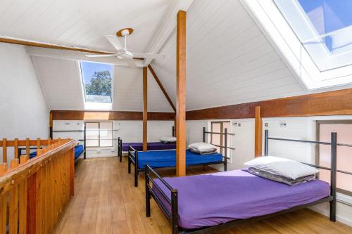 拜伦湾Aquarius Backpackers Resort的带三张床和天花板的客房