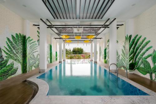 会安Thien Thanh Central Boutique Hotel by Minova的植物繁茂的建筑中间的游泳池