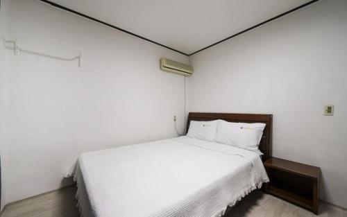 巨济Greenbeach motel 그린비치的卧室配有一张白色大床