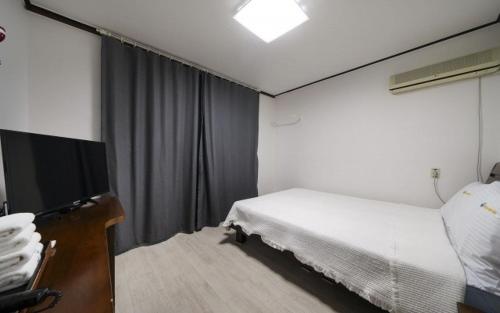 巨济Greenbeach motel 그린비치的配有一张床和一台平面电视的酒店客房