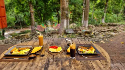 顺化YesHue Eco的一张木桌,上面放着两盘食物和饮料