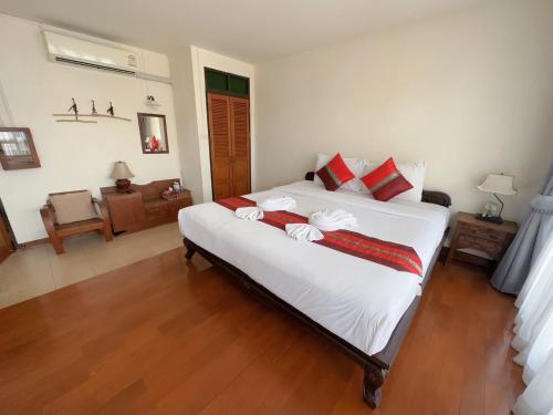 清迈乡村宾馆的卧室配有带红色枕头的大型白色床
