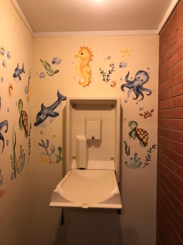 沃拉鲁Cornucopia hotel的浴室设有卫生间,墙上贴有标签