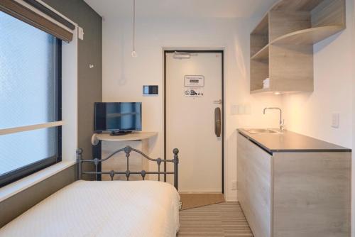 东京HJ PLACE TAKANAWA的一间带床和水槽的小卧室