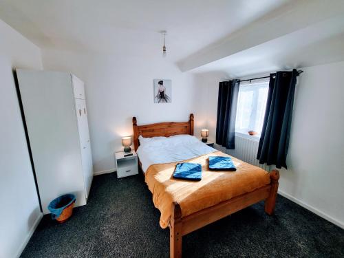 HeeleyStay Sleep Rest Heeley, Sheffield的一间卧室配有一张带两个蓝色枕头的床