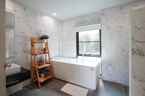 南芭堤雅Viva Montane Hotel Pattaya的白色的浴室设有白色浴缸和窗户。