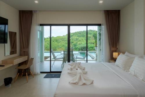 南芭堤雅Viva Montane Hotel Pattaya的一间带一张白色大床的卧室和一个阳台