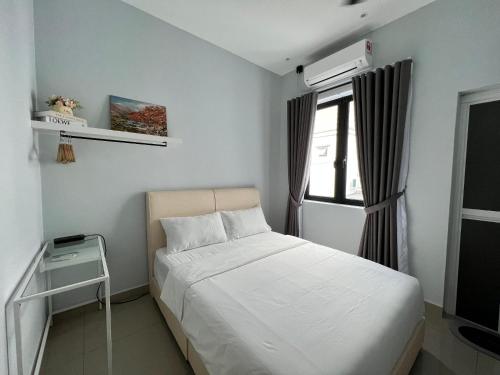 太平Luxe J Homestay的卧室配有白色的床和窗户。