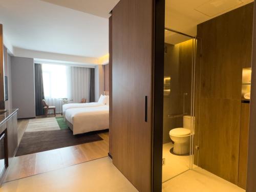 佳木斯佳木斯万达锦寓公寓酒店的酒店客房设有一张床和一个卫生间。