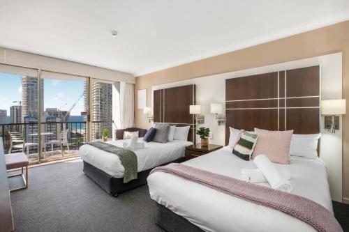 黄金海岸Comfy Surfers Paradise Studio with Ocean View的酒店客房设有两张床和一个阳台。