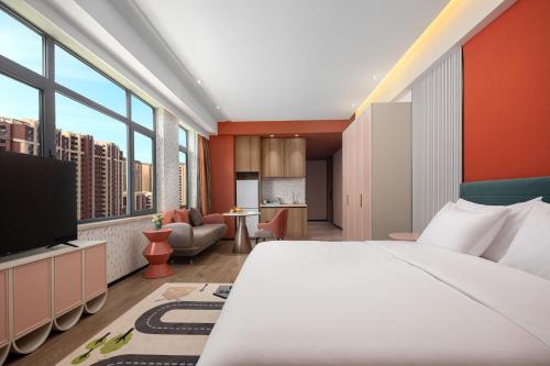 佳木斯佳木斯万达锦寓公寓酒店的酒店客房设有一张大床和一台电视。