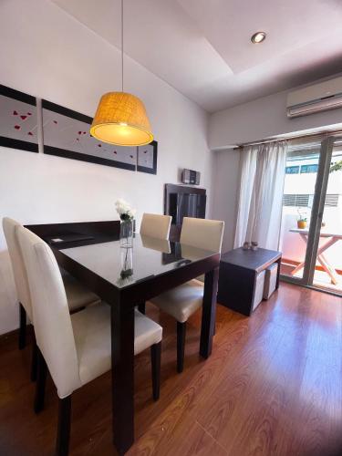 拉普拉塔La Plata Housing I的一间用餐室,配有黑桌和白色椅子