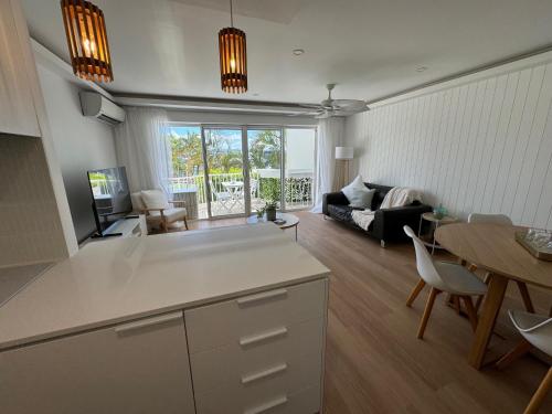 黄金海岸鹈鹕湾公寓酒店的厨房以及带沙发和桌子的客厅。