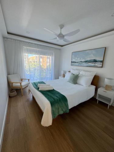 黄金海岸鹈鹕湾公寓酒店的卧室设有一张白色大床和一扇窗户。