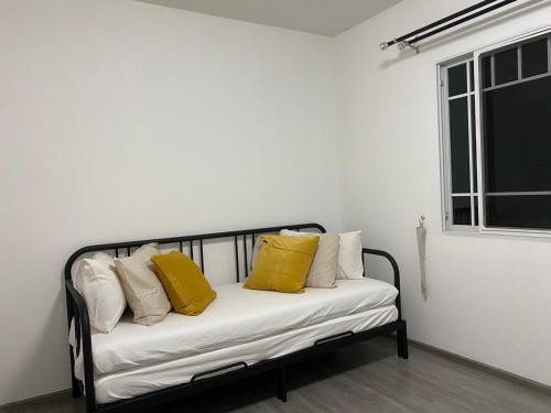 Bang Kew YaiIndy 2 Bangna KM 7 Cozy Townhome near Ikea Mega Bangna 15m to Airport的一张黑色和白色的沙发,上面有黄色枕头