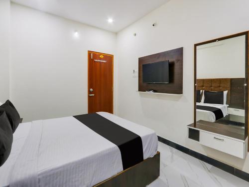 KhammamSuper OYO Hotel Arjun Residency的酒店客房,配有床和电视