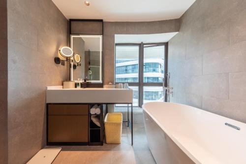 肇庆肇庆七星岩亚朵酒店的带浴缸、水槽和镜子的浴室