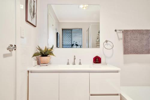 Henley Beach SouthHenley Hideaway的白色的浴室设有水槽和镜子