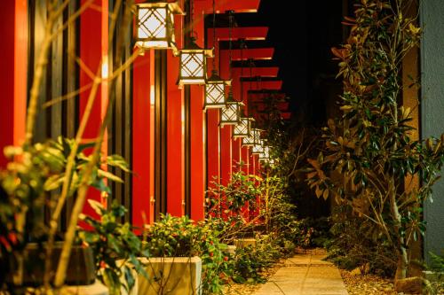 奈良奈良艾思酒店的走廊上种植了植物,墙上挂着红色的墙
