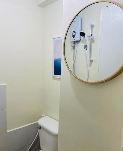 马尼拉Urban Deca Tower EDSA的一间带镜子和卫生间的浴室