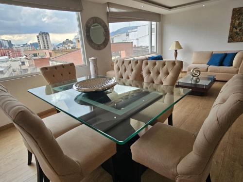 基多Confortable, moderno y hermoso departamento.的客厅配有玻璃桌和椅子