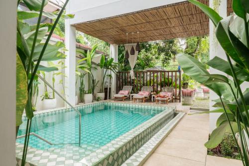 龙目岛库塔Naia Lombok的一个带凉亭和庭院家具的室外游泳池