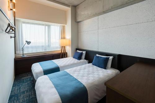川崎川崎国王天际东急REI酒店的酒店客房设有两张床和窗户。
