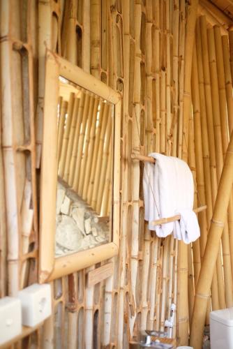 WaikeloMaringi Sumba by Sumba Hospitality Foundation的挂在竹墙上的镜子和毛巾
