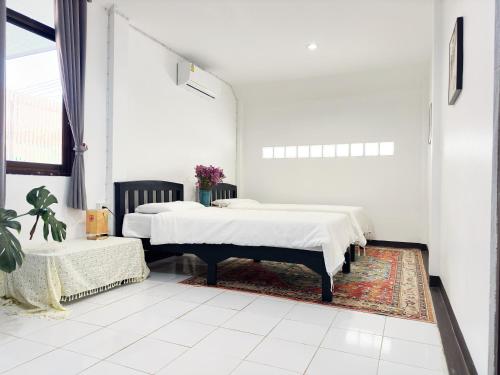 清迈An‘s Home的白色客房的两张床,铺有地毯