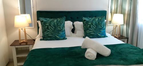 德班Durban Point Waterfront, 505 Quayside 40 Canalquay Rd的一间卧室配有一张带两盏灯的绿床。