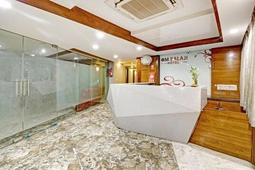 艾哈迈达巴德Hotel Om Balaji的一间带玻璃淋浴和水槽的浴室