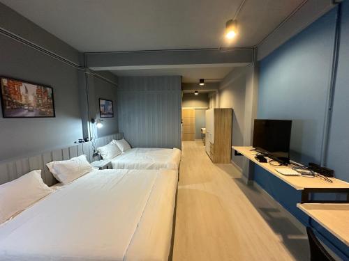 曼谷Bangkok vibe, City House, 7 mins to BTS, City center, Private room in Sathon, Private bathroom, Bangkok, Thailand的酒店客房设有两张床和电视。