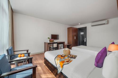 岘港班蒂克酒店的配有一张床和一把椅子的酒店客房
