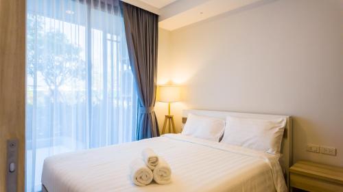 邦涛海滩Апартаменты в Laguna Skypark с террасой的一间卧室配有带毛巾的床