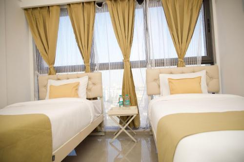 孟买Z Bliss Suites, BKC的一间卧室设有两张床和窗户。