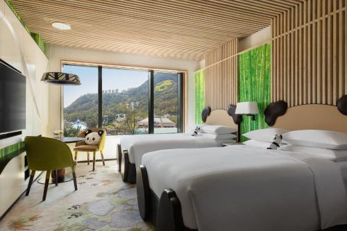 香港香港海洋公园万豪酒店的一间卧室设有四张床、一张桌子和一个窗户。
