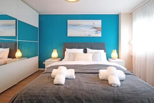 FontanaArena West Gem Apartment的一间卧室配有一张带蓝色墙壁的大床