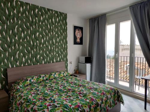 陶尔米纳Al Teatro Antico Rooms & House的一间卧室配有一张带绿色图案墙壁的床