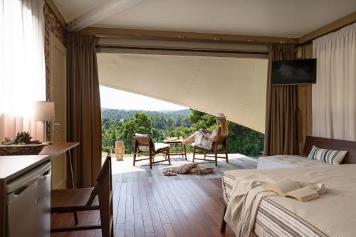 波利克罗诺iHouseVILLAGE的酒店客房设有两张床和大窗户。
