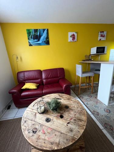 MontmorotLes Salines的客厅配有红色的沙发和木桌